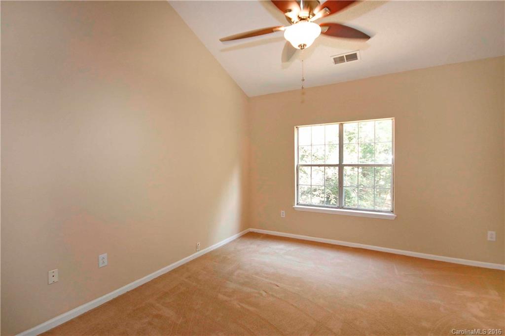 11931 Harris Ridge Drive Charlotte, NC 28269 - Photo 9 of 19 an empty room with a chandelier fan and windows