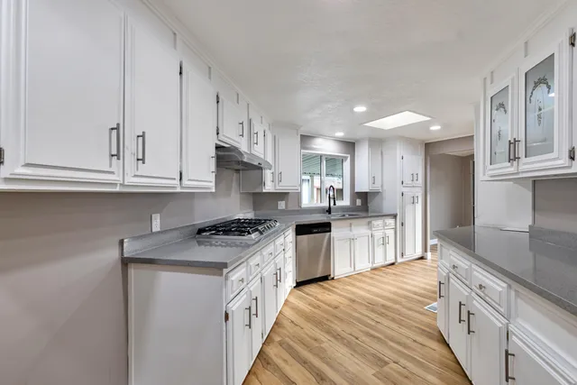 a kitchen with stainless steel appliances granite countertop a stove a sink and a refrigerator