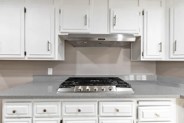 a stove top oven sitting inside of a kitchen