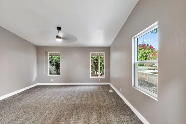 an empty room with windows and closet