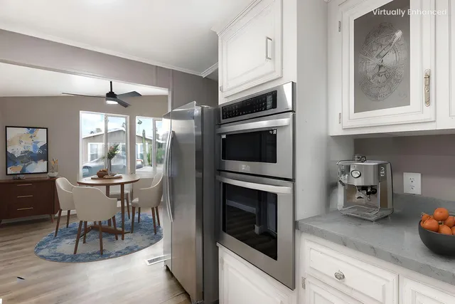 a kitchen with granite countertop white cabinets stainless steel appliances and a counter space