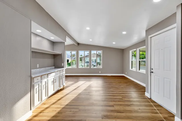 a view of an empty room and wooden floor and windows