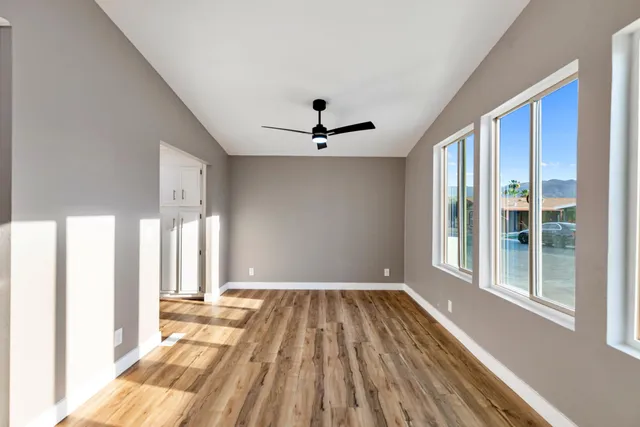 a view of a livingroom with wooden floor and a ceiling fan