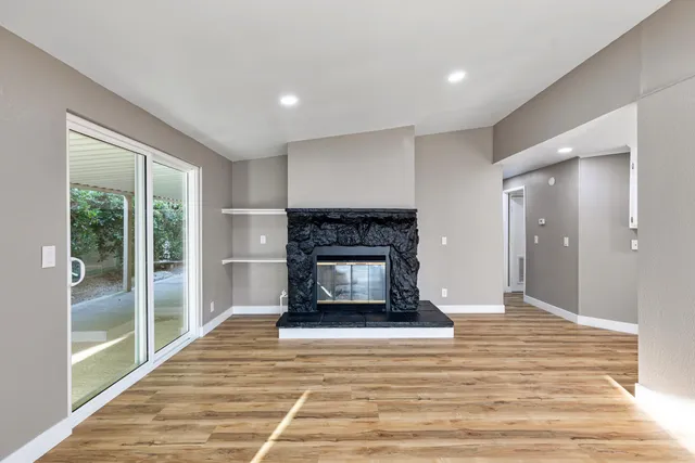 a living room with a fireplace and a floor to ceiling window