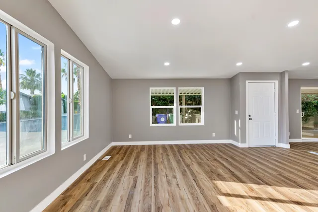 a view of a room with a window and wooden floor