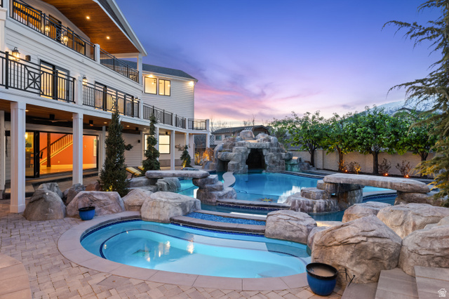 1263 Chapman Court Alpine, UT 84004 - Photo 8 of 83 Pool at dusk featuring a patio, a balcony, and a pool with connected hot tub