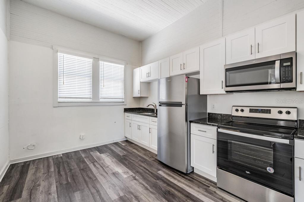 2319 West Aileen Street, Unit B Tampa, FL 33607 - Photo 11 of 19 a kitchen with cabinets stainless steel appliances and wooden floor