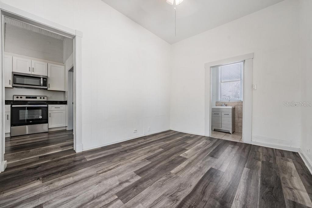 2319 West Aileen Street, Unit B Tampa, FL 33607 - Photo 13 of 19 an empty room with wooden floor kitchen view and a window