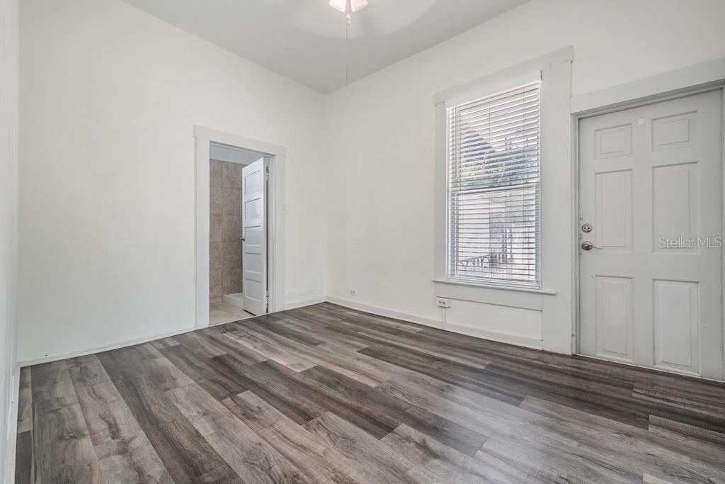 2319 West Aileen Street, Unit B Tampa, FL 33607 - Photo 6 of 19 a view of empty room with wooden floor and fan