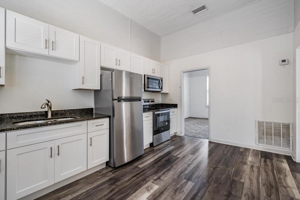 2319 West Aileen Street, Unit B Tampa, FL 33607 - Photo 10 of 19 a kitchen with granite countertop white cabinets and stainless steel appliances
