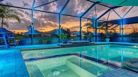 a view of a swimming pool with a patio and a yard