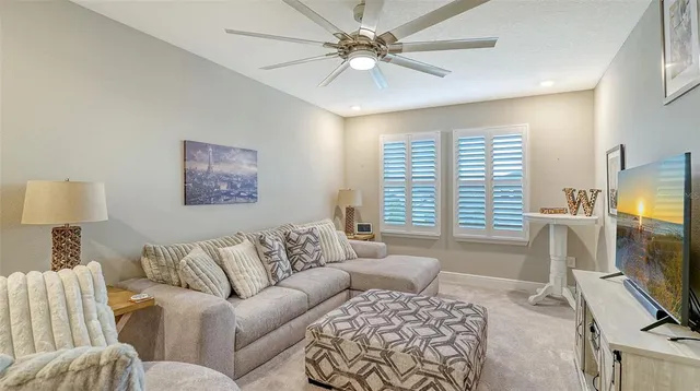 a living room with furniture a flat screen tv and a window
