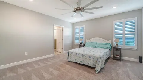 a bedroom with a bed and a ceiling fan