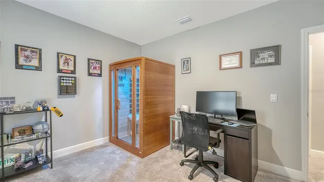 a view of a workspace with furniture and a window
