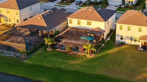 an aerial view of residential houses with outdoor space and parking