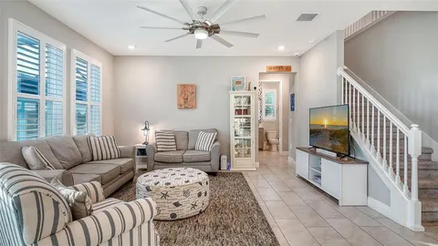 a living room with furniture ceiling fan and a rug