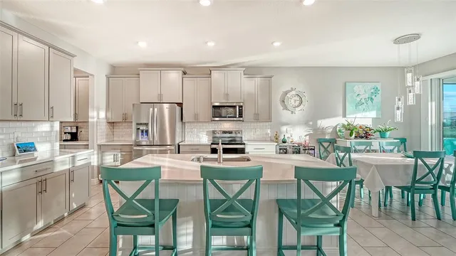a kitchen with stainless steel appliances a table and chairs in it