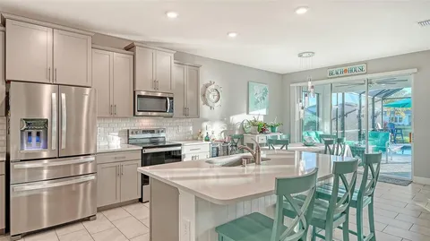 a kitchen with a refrigerator and a stove top oven