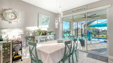 a dining room with furniture water view and a floor to ceiling window
