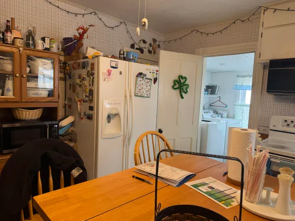 a open kitchen with a refrigerator and a stove top oven