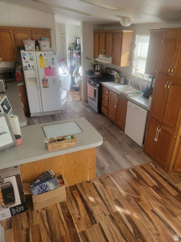 2180 North 1950th Street West Helper, UT 84526 - Photo 7 of 11 Kitchen featuring wood finish cabinets, dark wood finished floors, and white appliances