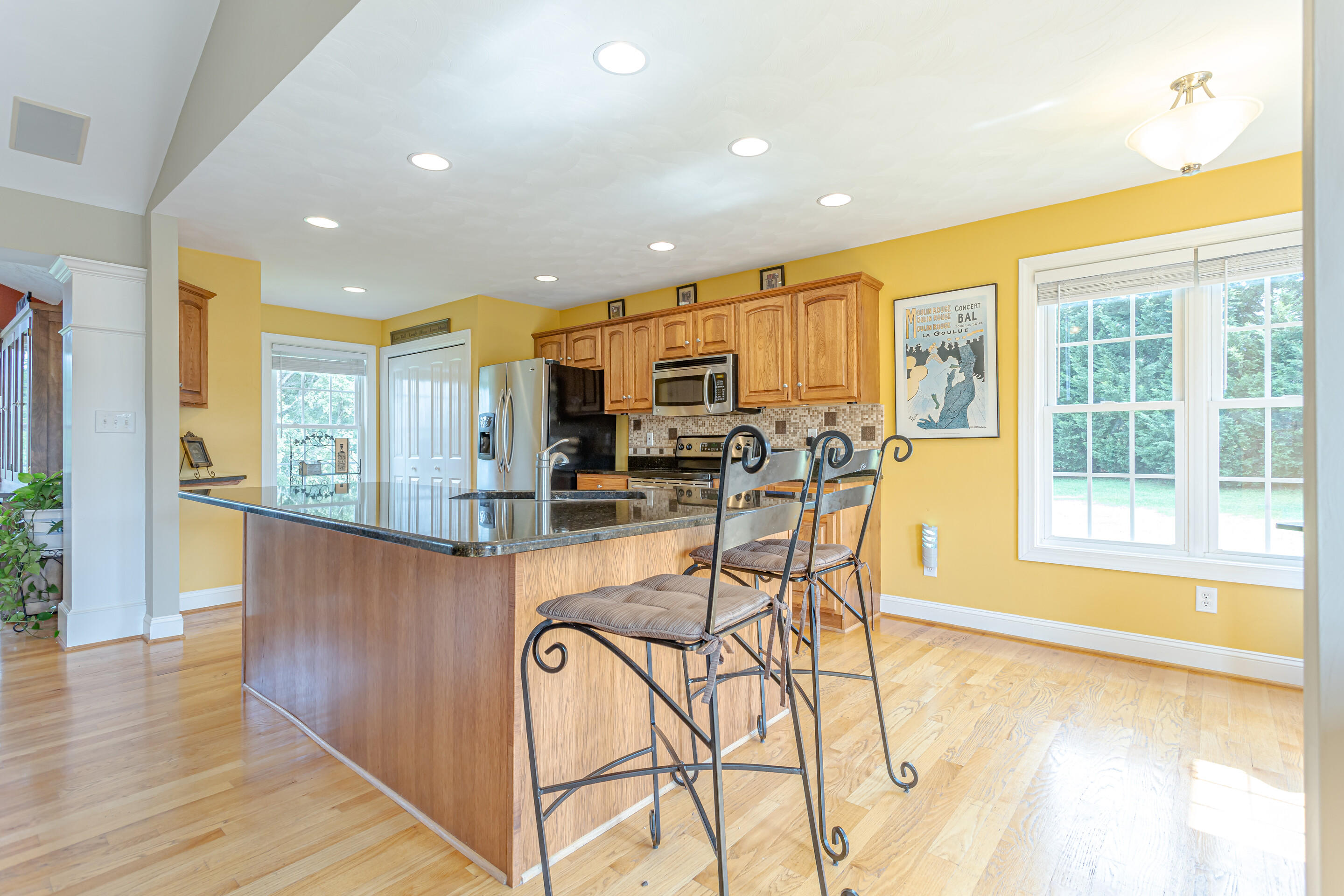 4510 Bethlehem Road Boones Mill, VA 24065 - Photo 11 of 48 a kitchen with stainless steel appliances granite countertop a refrigerator a stove a sink a dining table and chairs with wooden floor