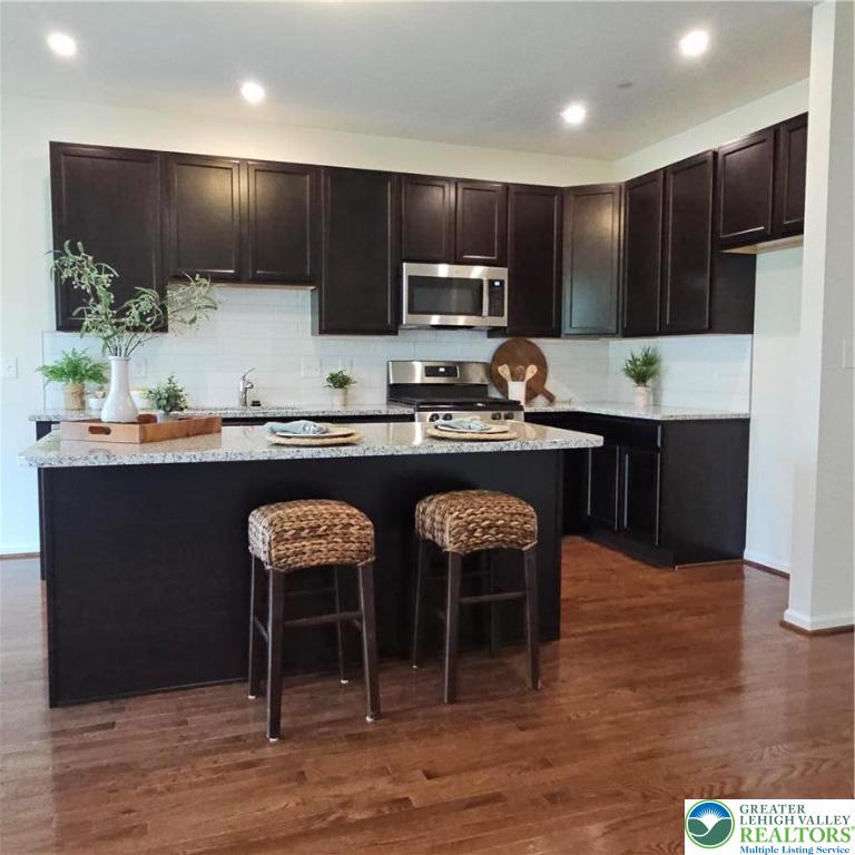 629 Fountain View Circle, Unit 8 Allentown, PA 18104 - Photo 2 of 16 a kitchen with kitchen island granite countertop a sink and a stove