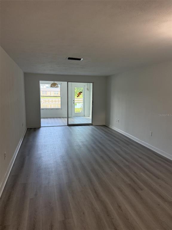 4413 Sunstate Drive New Port Richey, FL 34652 - Photo 6 of 14 an empty room with wooden floor and windows