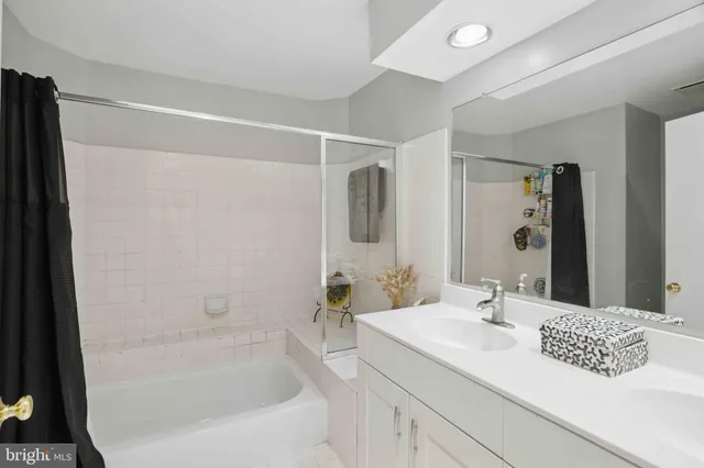 a bathroom with a bathtub sink vanity and mirror