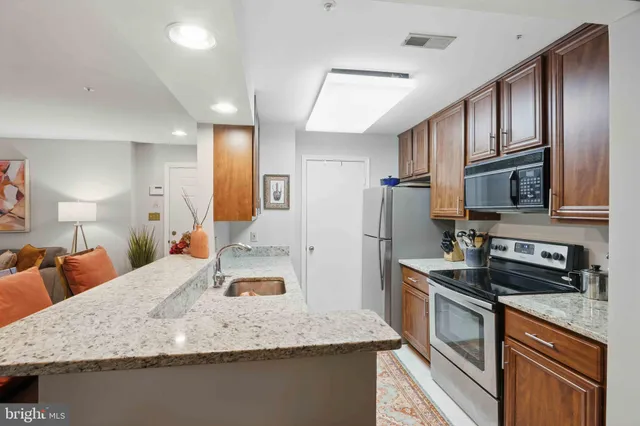 a kitchen with stainless steel appliances granite countertop a sink refrigerator and cabinets