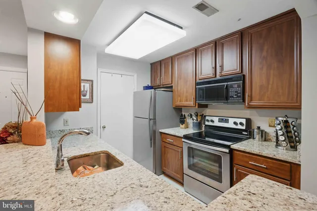 a kitchen with stainless steel appliances granite countertop a refrigerator stove and sink