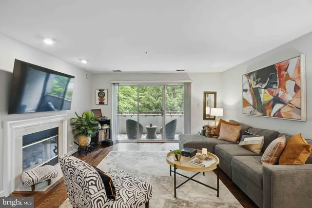 a living room with furniture a flat screen tv and a fireplace