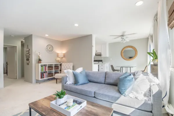 a living room with furniture and a dining table with wooden floor