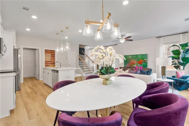 a dining room with furniture a chandelier and kitchen view
