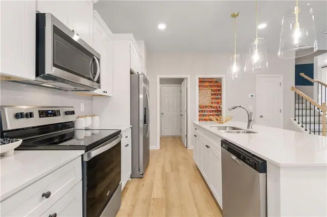 a kitchen with stainless steel appliances granite countertop a sink a stove and a wooden floors
