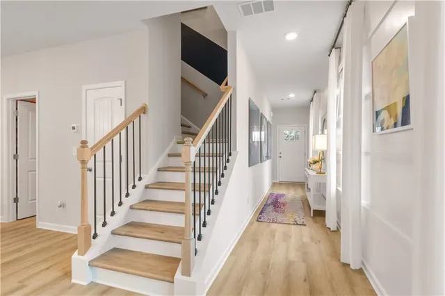 a view of a hallway with wooden floor and staircase