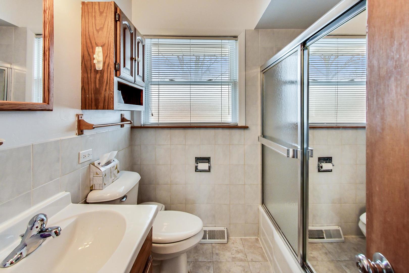 1022 Ridge Road Highland Park, IL 60035 - Photo 11 of 17 a bathroom with a sink a toilet and shower