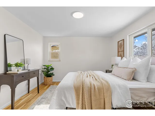 a bedroom with a bed and a painting on the wall