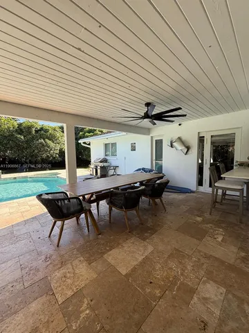 a view of a patio with a table and chairs under an umbrella