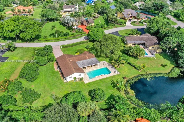 an aerial view of a house with a garden and lake view