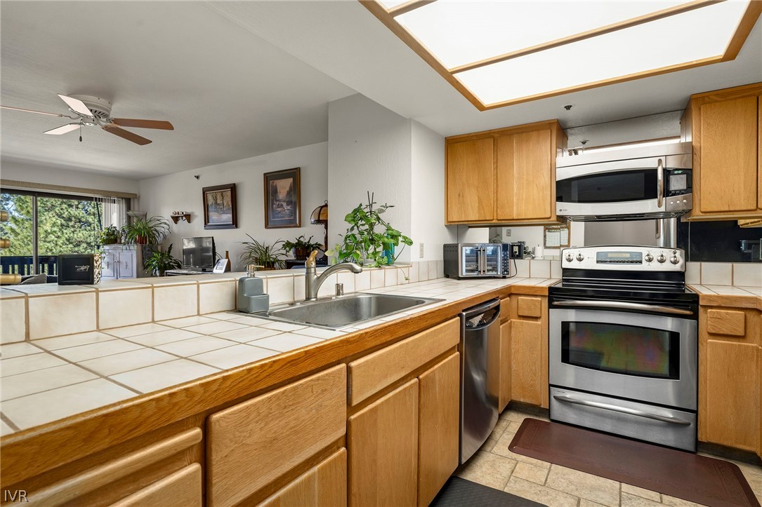 335 Ski Way, Unit 337 Incline Village, NV 89451 - Photo 9 of 23 a kitchen with stainless steel appliances kitchen island granite countertop a stove a sink and a microwave