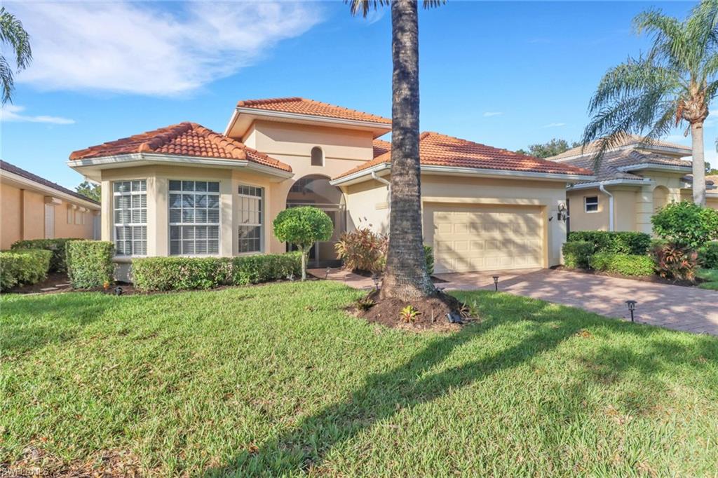 6757 Bent Grass Drive Naples, FL 34113 - Photo 2 of 27 a front view of a house with garden