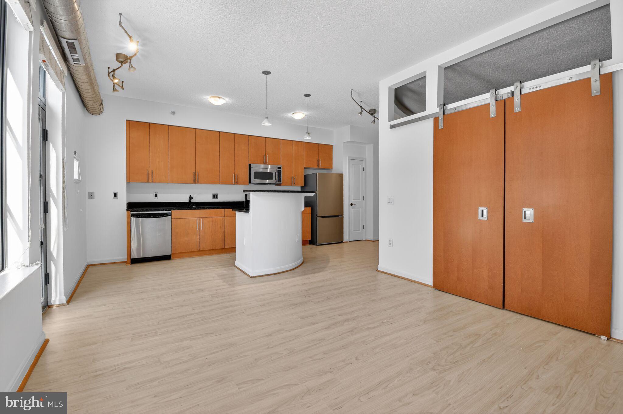 1390 Kenyon Street Northwest, Unit 319 Washington, DC 20010 - Photo 3 of 38 a view of a kitchen with a refrigerator and a microwave