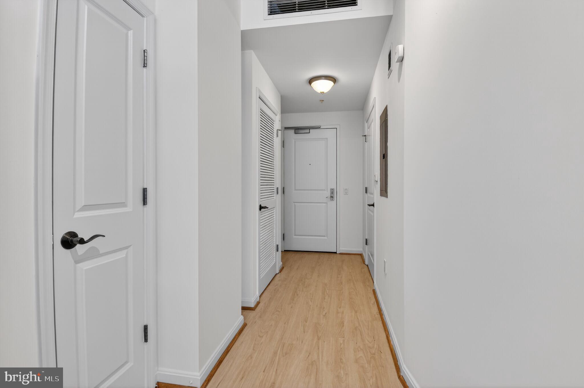 1390 Kenyon Street Northwest, Unit 319 Washington, DC 20010 - Photo 4 of 38 a view of a hallway with wooden floor and a shower