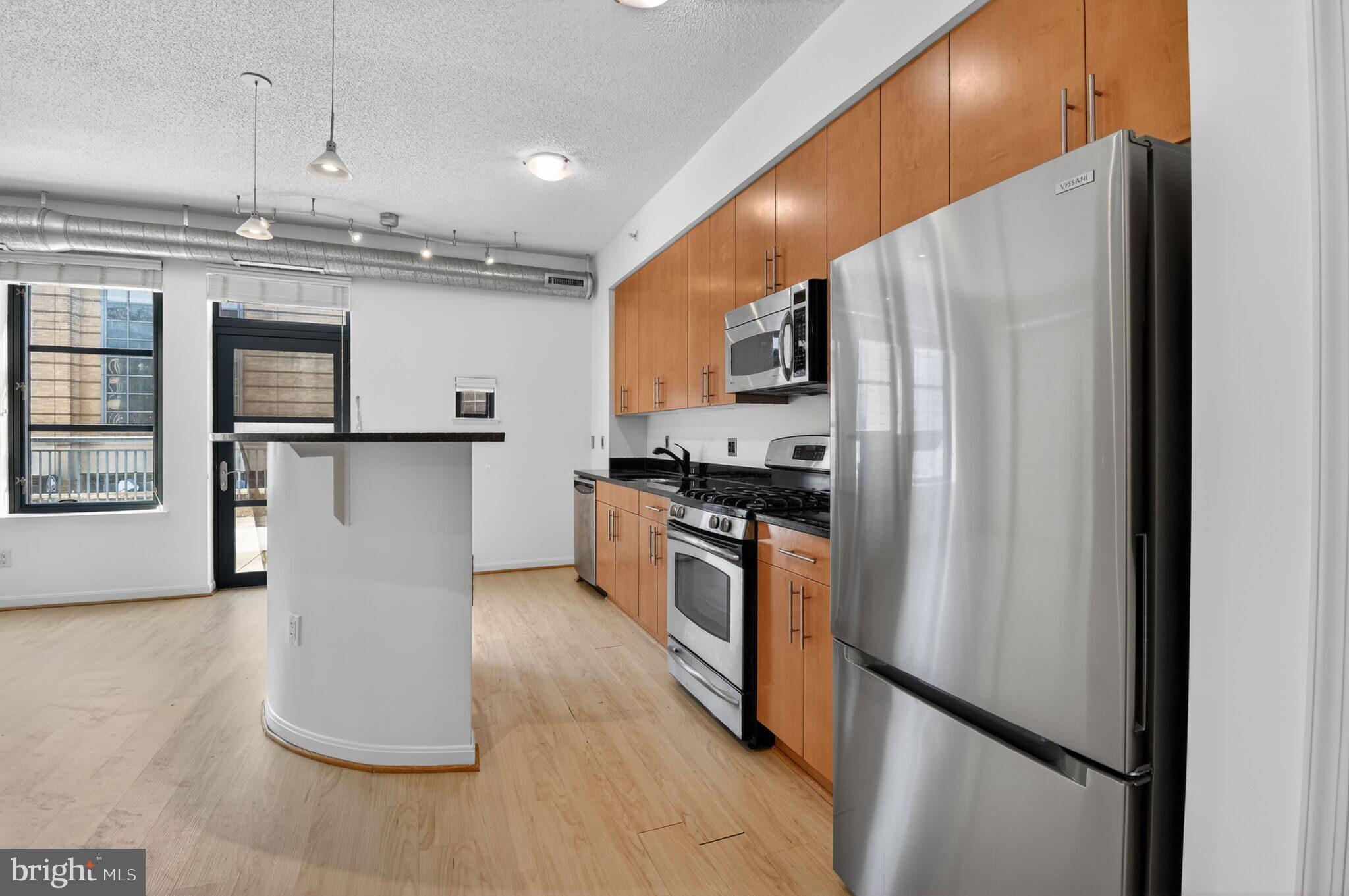 1390 Kenyon Street Northwest, Unit 319 Washington, DC 20010 - Photo 8 of 38 a kitchen with stainless steel appliances granite countertop a refrigerator a stove and a sink