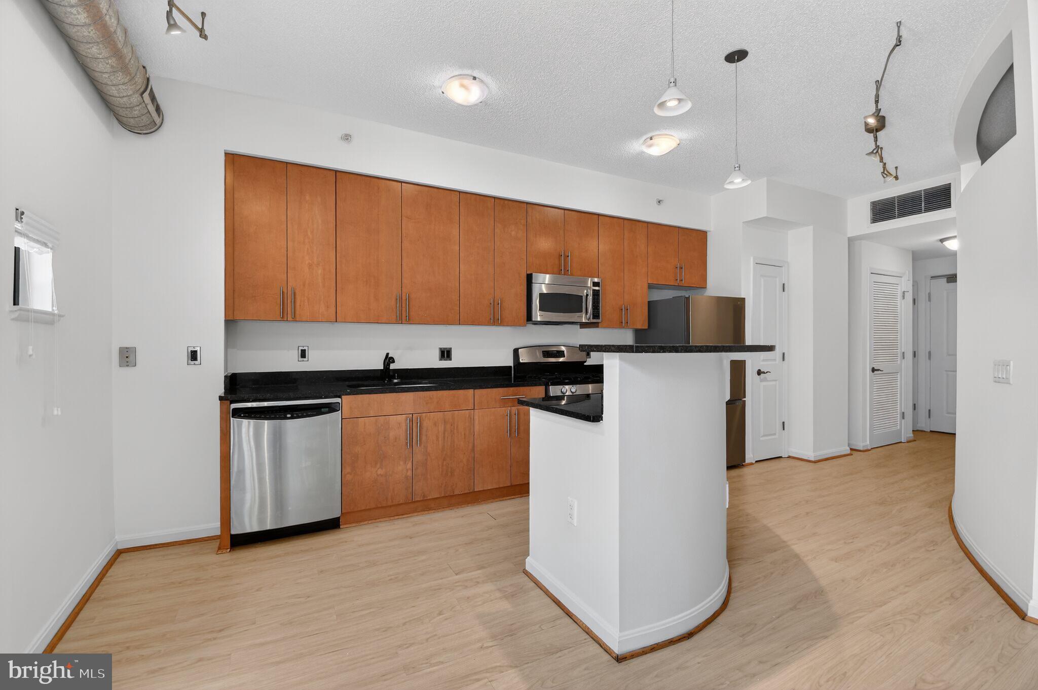 1390 Kenyon Street Northwest, Unit 319 Washington, DC 20010 - Photo 9 of 38 a view of kitchen with stainless steel appliances granite countertop refrigerator sink and stove