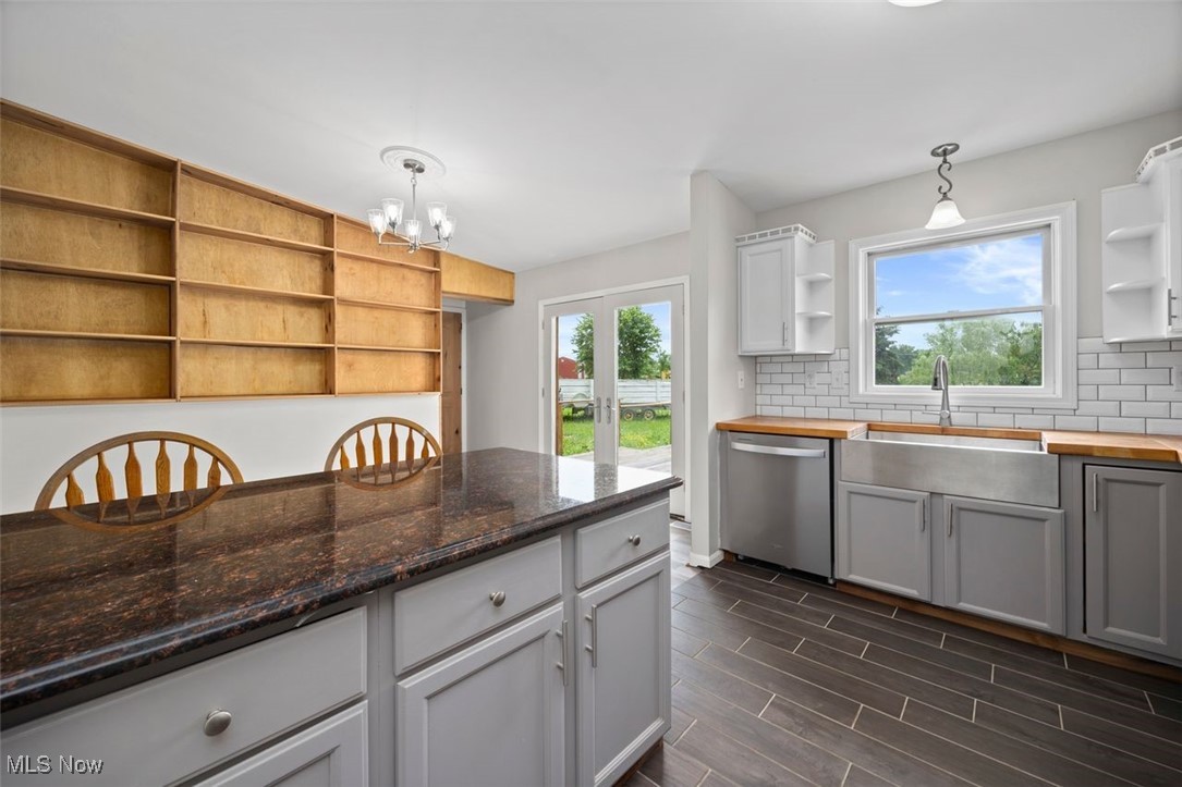 1515 Butler Road New London, OH 44851 - Photo 15 of 39 Kitchen featuring open shelves, stainless steel dishwasher, backsplash, and healthy amount of natural light