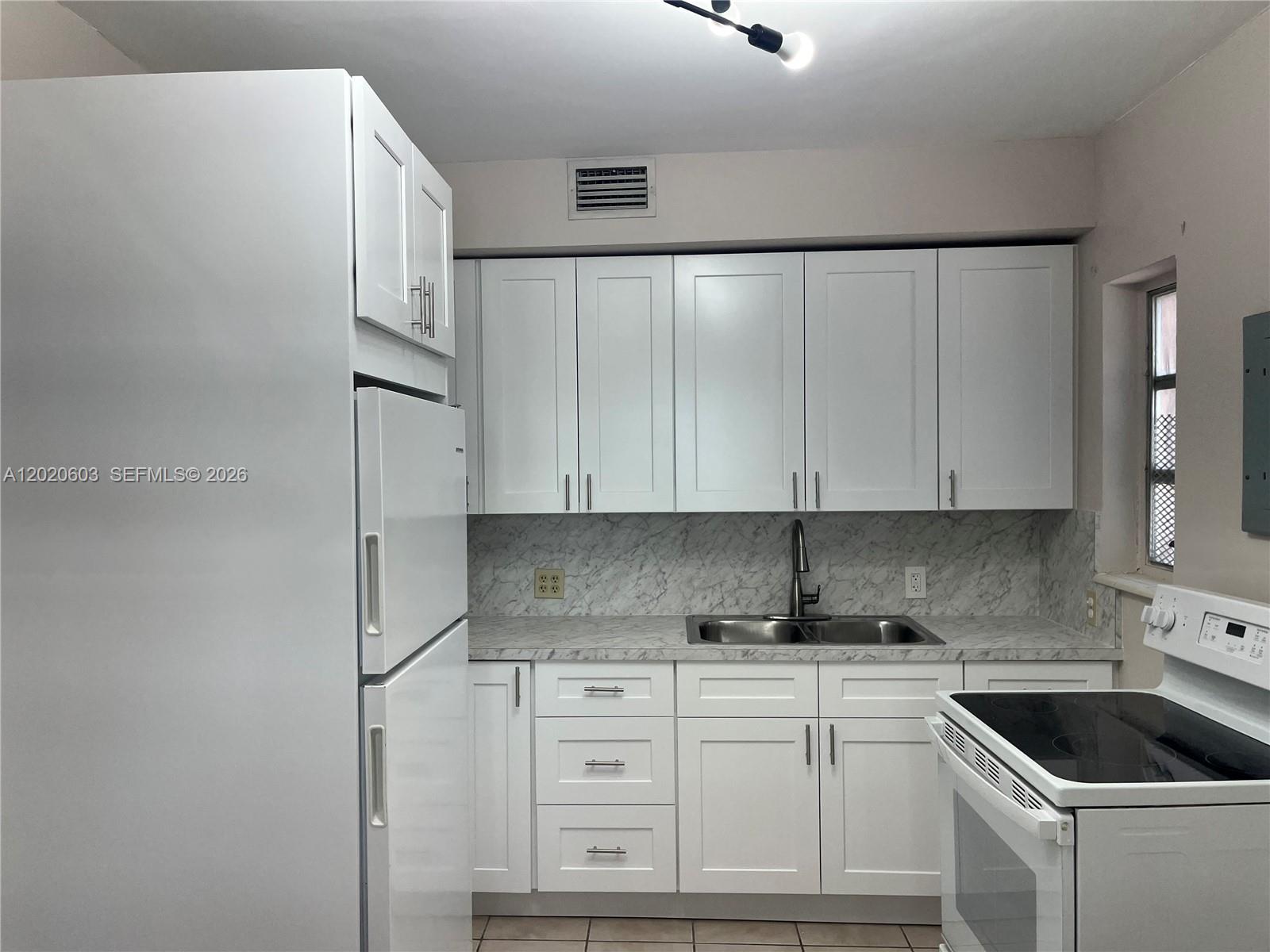 3750 Southwest 27th Street Miami, FL 33134 - Photo 2 of 4 a kitchen with granite countertop white cabinets and white appliances