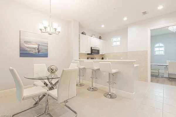 a kitchen with kitchen island a dining table chairs cabinets and stainless steel appliances