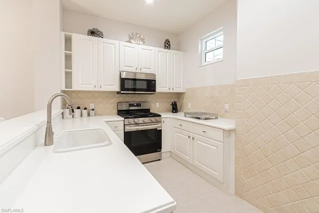 a kitchen with stainless steel appliances a stove a sink and a microwave